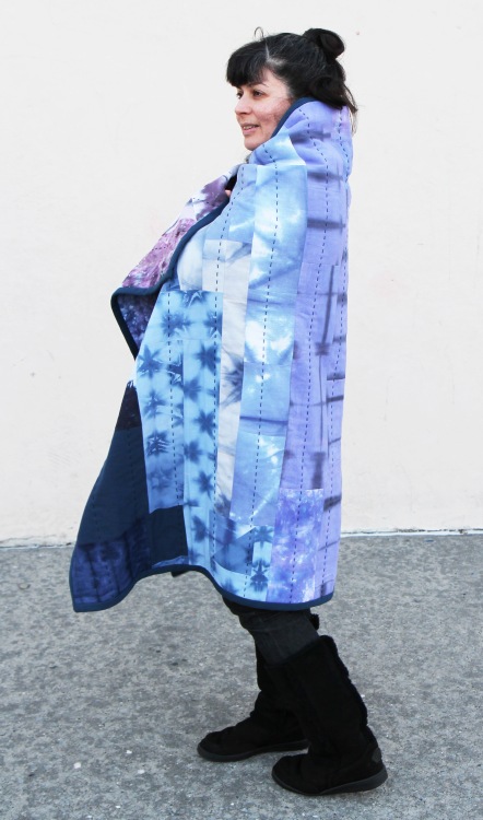 woman with colorful patchwork quilt wrapped around herself